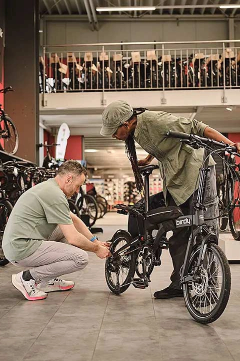 Ein Fachhändler berät eine Kundin mit Klapprad