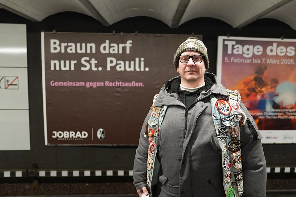 St. Pauli Fan vor Plakat "Braun darf nur St. Pauli" in U-Bahn Station